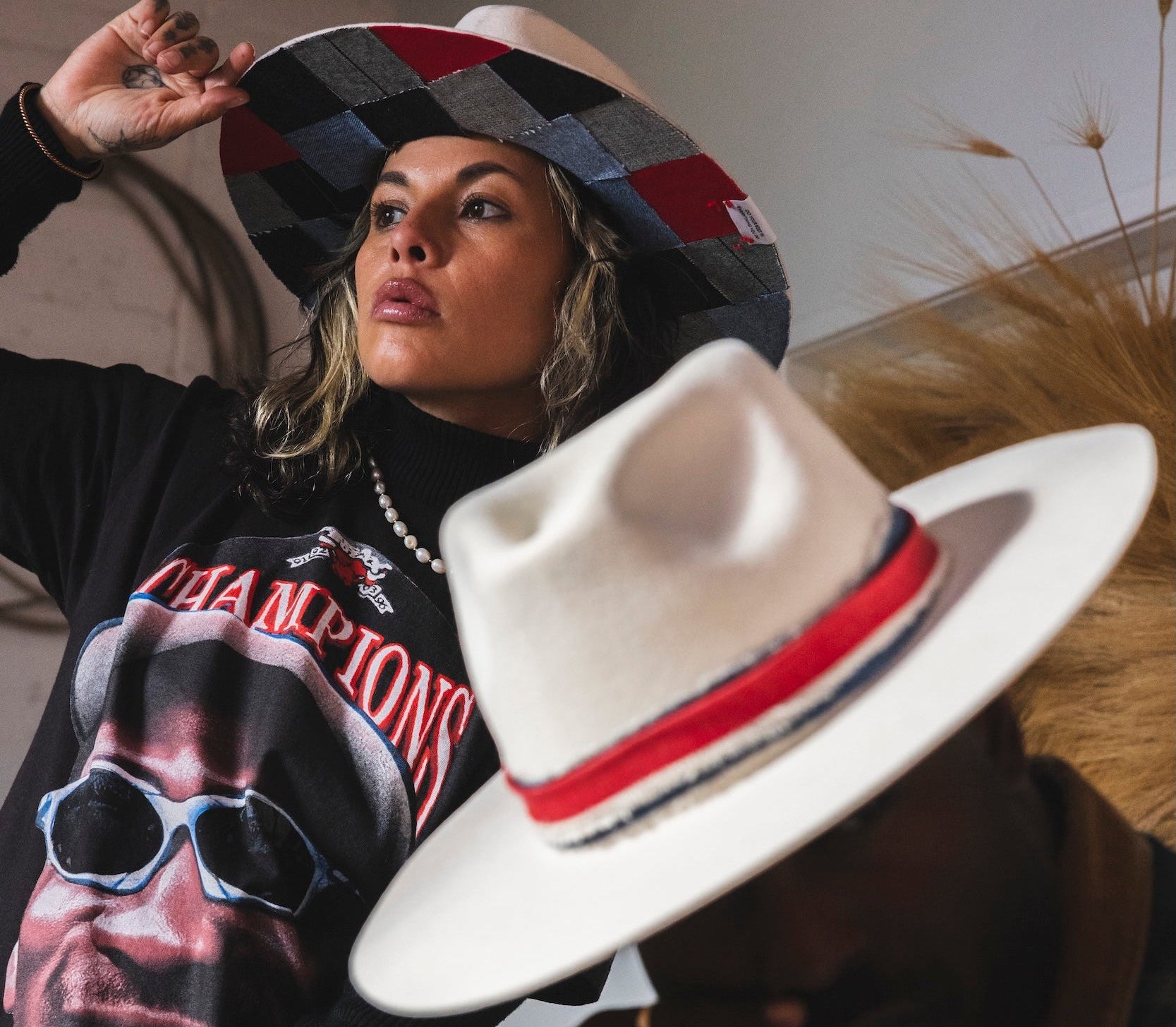 Two people wearing hats and casual clothing indoors.